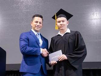 Principal posing with graduating senior