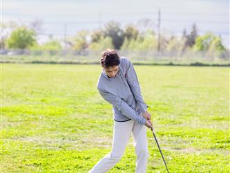 Golf player swinging ball