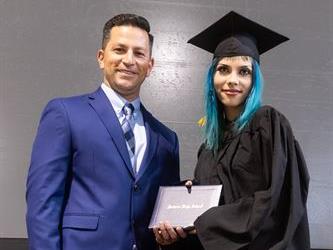 Principal posing with graduating senior