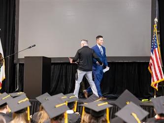 Two men shaking hands on stage