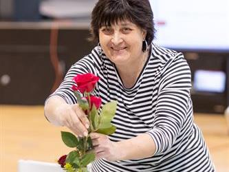 Woman putting flower in vase
