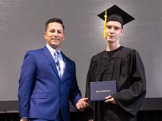 Principal posing with graduating senior
