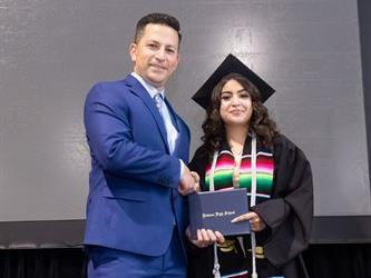 Principal posing with graduating senior