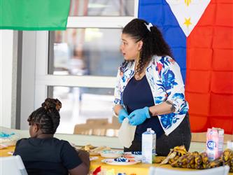 A student is painting while another is watching to the side 