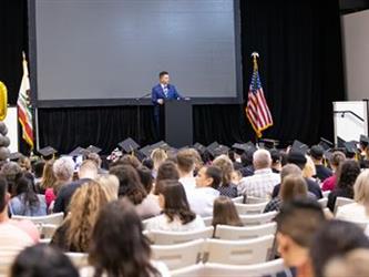 Distance shot of principal speaking on stage