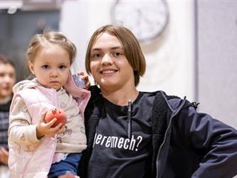 Woman holding child smiling for camera