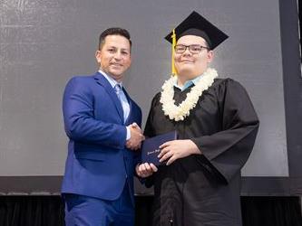 Principal posing with graduating senior