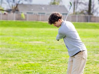 Golf player swinging ball