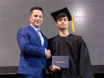 Principal posing with graduating senior