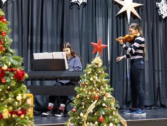 Girl playing violin and another playing the piano