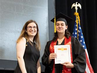 Graduate showing off certificate with staff