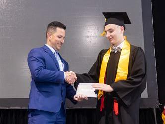 Principal posing with graduating senior