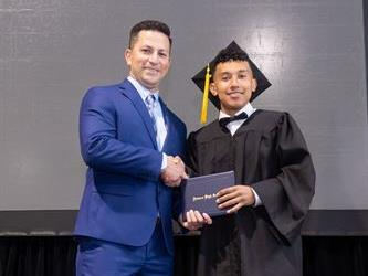 Principal posing with graduating senior