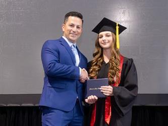 Principal posing with graduating senior