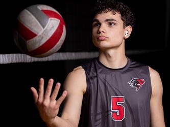 Volleyball player throwing ball in air