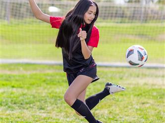 Girls soccer team player doing a trick