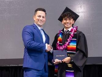 Principal posing with graduating senior