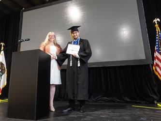 Superintendent speaking at podium recognizing student
