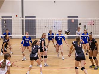 Girls playing indoor volleyball