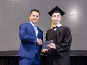 Principal posing with graduating senior