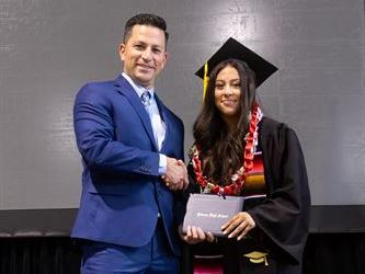 Principal posing with graduating senior