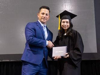 Principal posing with graduating senior