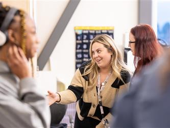 A staff member is engaging with students 
