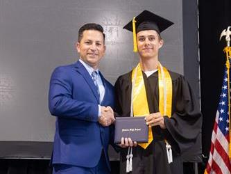 Principal posing with graduating senior
