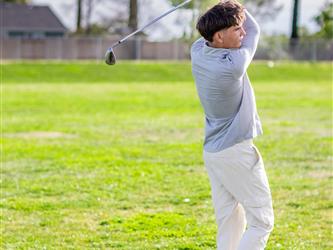 Golf player swinging ball