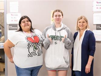 Two students are pictured with a teacher