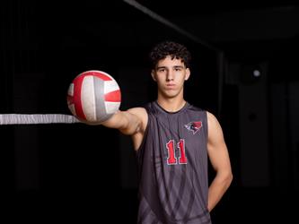 Volleyball player posing with ball outstretched