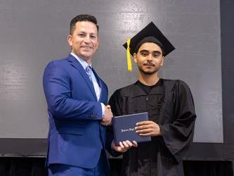 Principal posing with graduating senior