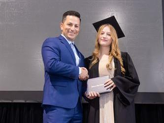 Principal posing with graduating senior