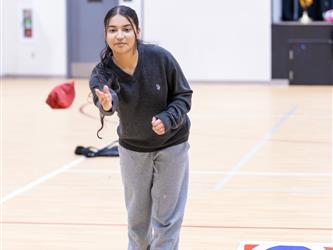 Student is in motion of throwing a bean bag