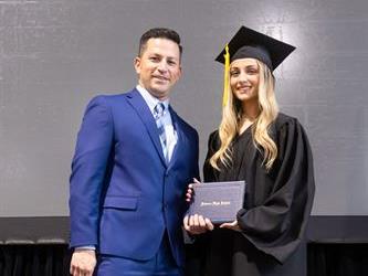 Principal posing with graduating senior