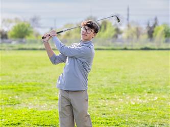 Golf player swinging ball