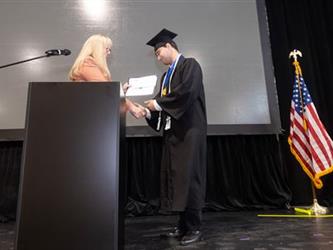 Superintendent speaking at podium recognizing student