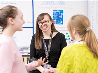 Two students and a teacher are enjoying a conversation