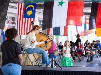 Student playing harp like instrument