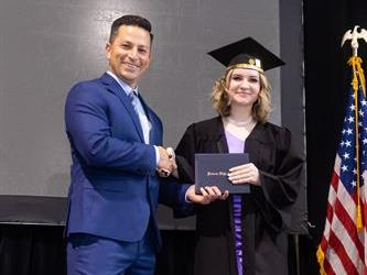 Principal posing with graduating senior