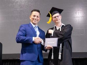 Principal posing with graduating senior