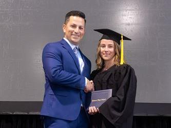 Principal posing with graduating senior