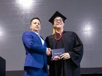 Principal posing with graduating senior