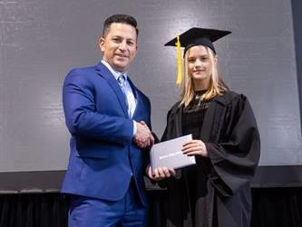 Principal posing with graduating senior