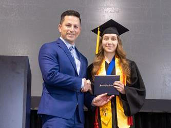 Principal posing with graduating senior