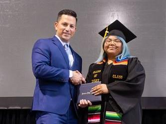 Principal posing with graduating senior