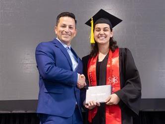 Principal posing with graduating senior