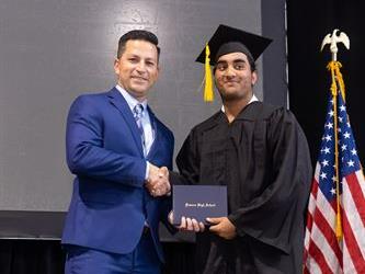 Principal posing with graduating senior