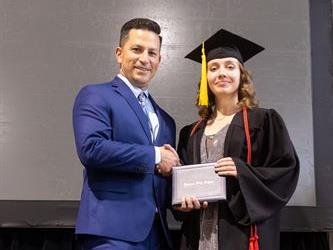 Principal posing with graduating senior