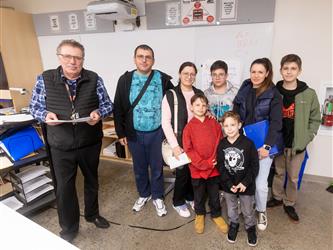 A teacher is pictured with a family of 7 in a class